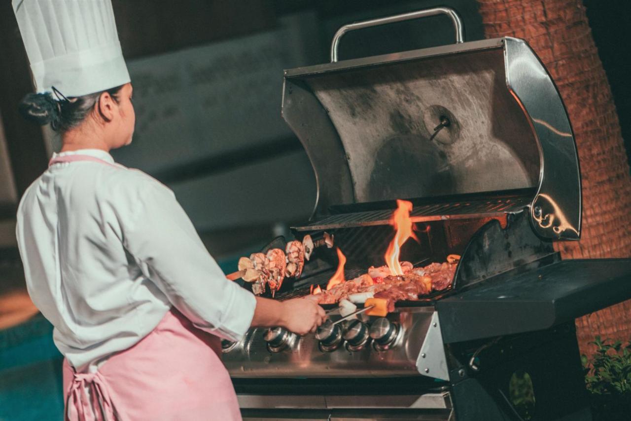 알 메실라, 어 럭셔리 컬렉션 리조트 앤 스파, 도하 외부 사진 A chef cooking on a gas grill