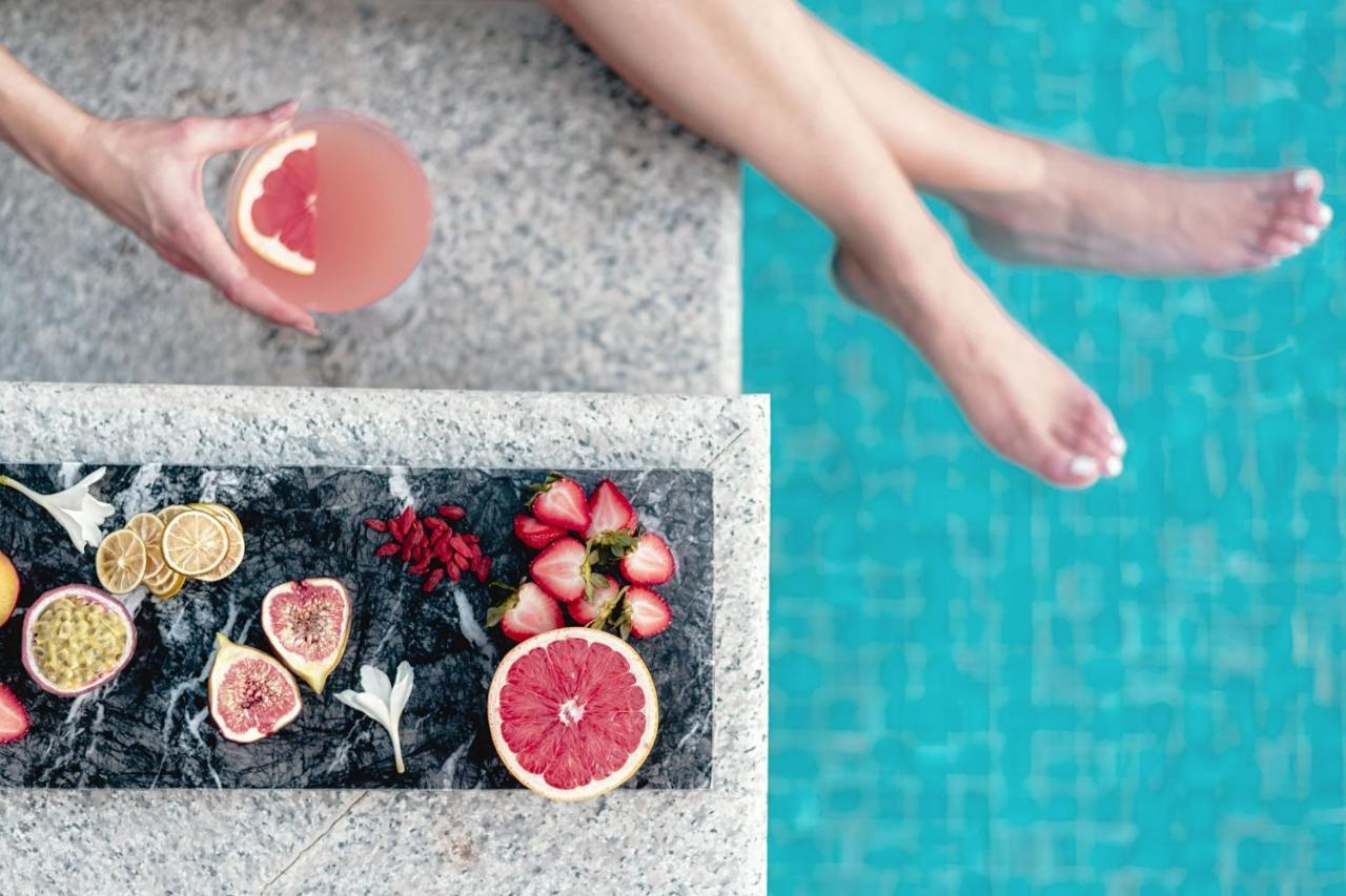 알 메실라, 어 럭셔리 컬렉션 리조트 앤 스파, 도하 외부 사진 A woman holding a grapefruit cocktail